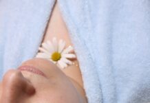 여름철 운동 후 피부 진정 팩 사용법 woman wearing blue robe lying with cucumber on eye