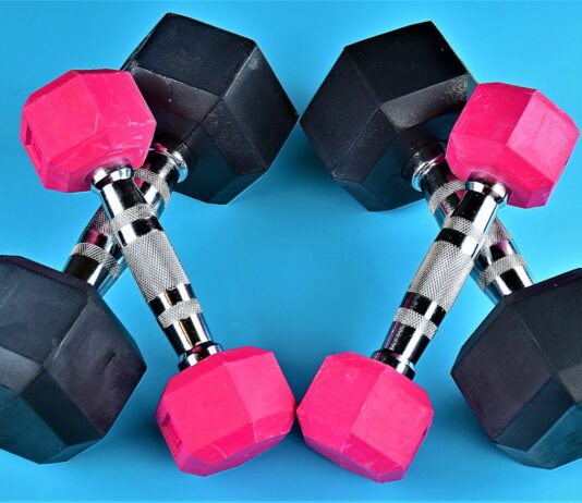 장기적인 건강을 위한 운동의 필요성 a pair of pink and black dumbs on a blue background