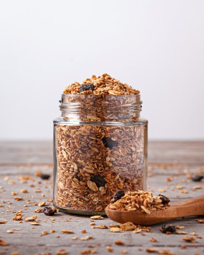Photo by Mayte Baque A jar filled with granola next to a wooden spoon