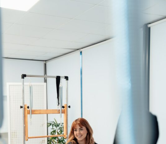 필라테스로 몸의 균형 찾기: 신체 정렬의 중요성 a woman is riding a stationary rowing machine